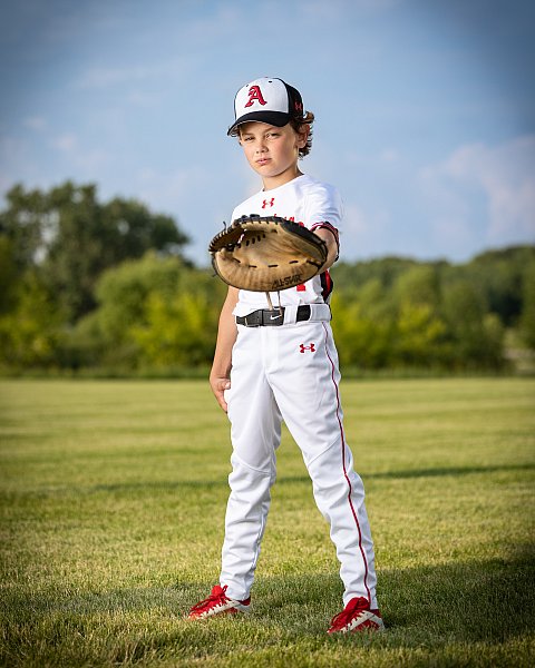 baseball player holds out glove outside sports photo day portrait